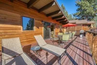 a deck with chairs and a table and an umbrella at Peaceful Forest Retreat Near Lake and Town in Tahoe City
