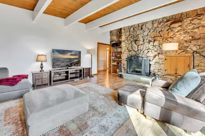 a living room with a stone wall with a fireplace at Peaceful Forest Retreat Near Lake and Town in Tahoe City