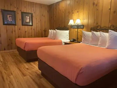 two beds in a hotel room with wooden walls at Timberline Lodge - Arnold - Bear Valley - Murphys in Arnold