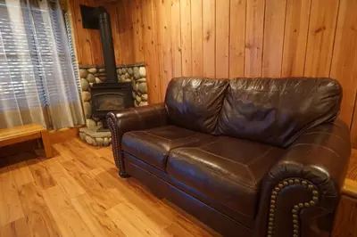 a leather couch in a living room with a stove at Timberline Lodge - Arnold - Bear Valley - Murphys in Arnold