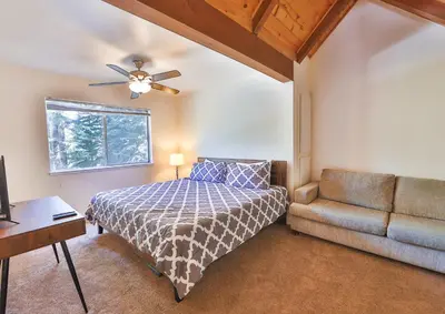a bedroom with a bed and a couch at Iroquois Ridge Hot Tub Near Lake Tahoe & Skiing in South Lake Tahoe