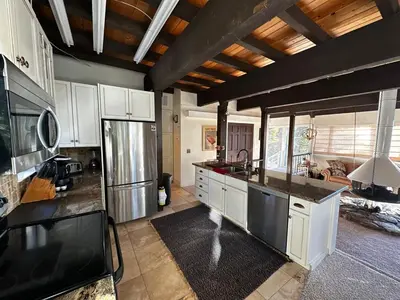 a kitchen with white cabinets and black counter tops at Modern Rustic Lux Tahoe Cabin in Carnelian Bay