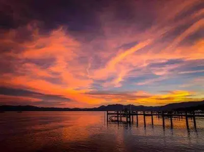 a sunset over a body of water with a pier at Modern Rustic Lux Tahoe Cabin in Carnelian Bay
