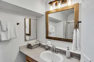 a white bathroom with a sink and a mirror at Wooded Getaway Steam Shower plus Hot Tub in Tahoe City
