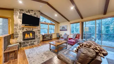 a living room with a fireplace and a television at Cozy Tahoe Retreat w Hot Tub Movie Room Forest Views 10th ave 2 by AvantStay in Tahoma