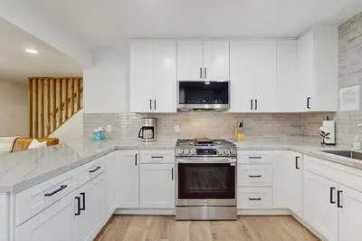 a kitchen with white cabinets and a stove top oven at The Pine Chalet in South Lake Tahoe
