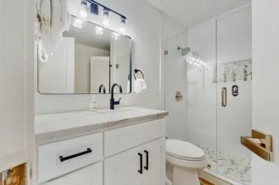 a white bathroom with a sink and a shower at The Pine Chalet in South Lake Tahoe