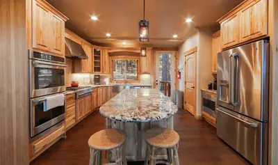 a kitchen with a center island with two stools at The T-Pot Chalet for 12 in South Lake Tahoe
