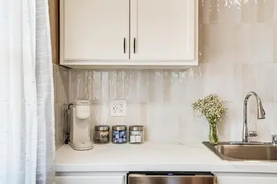 a kitchen with white cabinets and a sink and a counter at Couples Retreat! Shop, Dine, Explore Dtwn Oakdale in Oakdale