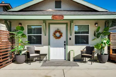 a house with chairs and a white door with a wreath at Couples Retreat! Shop, Dine, Explore Dtwn Oakdale in Oakdale