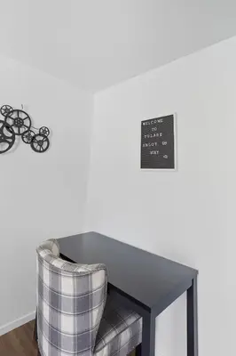 a couch sitting next to a table with a clock on the wall at The Cozy Rustic Sequoia Wi-Fi & 2 Garage in Tulare