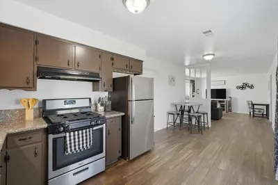 a kitchen with a stove and a refrigerator at The Cozy Rustic Sequoia Wi-Fi & 2 Garage in Tulare
