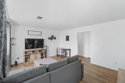 a living room with a couch and a flat screen tv at The Cozy Rustic Sequoia Wi-Fi & 2 Garage in Tulare
