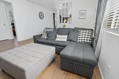 a living room with a couch and a ottoman at The Cozy Rustic Sequoia Wi-Fi & 2 Garage in Tulare