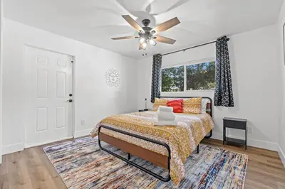 a bedroom with a bed and a ceiling fan at Cambridge Corner - Gateway to Sequoia Ntl Park in Visalia
