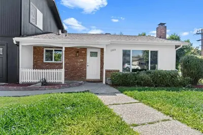 a brick house with a white door and grass at Cambridge Corner - Gateway to Sequoia Ntl Park in Visalia