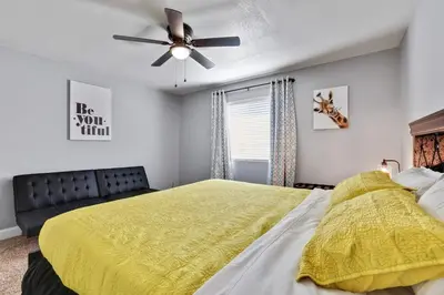 a bedroom with a yellow bed and a ceiling fan at The Royal Oak Splash Sequoia Nat'l Park Lake Mts in Visalia