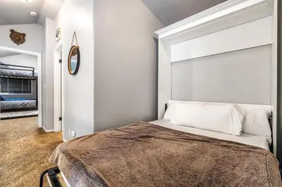 a bedroom with a bed with a large headboard at Halonas Cozy Cabin 2M To Lake in Shaver Lake