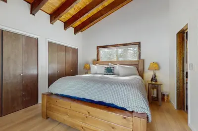 a bedroom with a bed and a wooden dresser at The Regan Beach Vista in South Lake Tahoe