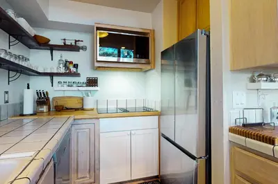 a kitchen with white cabinets and a stainless steel refrigerator at Dog-Friendly Retreat with Lake Views in Kings Beach in Kings Beach