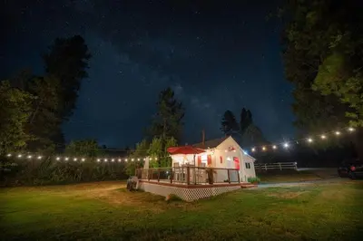 a house lit up at night with lights on it at Meadow Creek Cabin in Camino