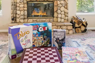 a pile of games on a table in front of a fireplace at The Trailhead Hot Tub, Hikes & Night Skies in Shaver Lake