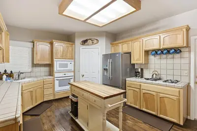 a kitchen with wooden cabinets and stainless steel appliances at The Trailhead Hot Tub, Hikes & Night Skies in Shaver Lake