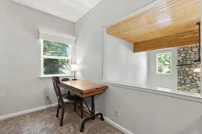 a home office with a wooden desk and two windows at The Trailhead Hot Tub, Hikes & Night Skies in Shaver Lake