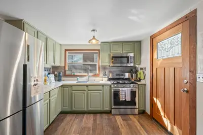 a kitchen with green cabinets and a refrigerator at HCH0648 - Larchwood Lodge home in South Lake Tahoe