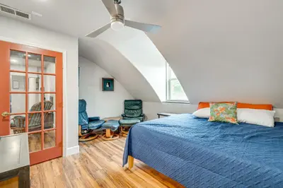 a bedroom with a blue bed and an attic at Easily Explore Fair Oaks Village! Unique Condo in Fair Oaks