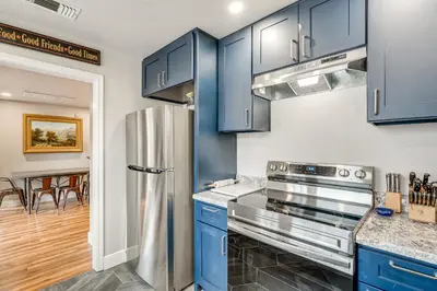 a kitchen with blue cabinets and a stainless steel refrigerator at Easily Explore Fair Oaks Village! Unique Condo in Fair Oaks