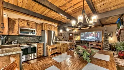 a kitchen with wooden cabinets and a dining room at COH0809 - Brule Haven home in South Lake Tahoe