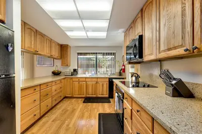a kitchen with wooden cabinets and wooden floors at Spacious Riverfront home in South Lake Tahoe