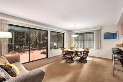 a living room with a table and chairs and a patio at Spacious Riverfront home in South Lake Tahoe