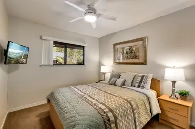 a bedroom with a bed and a ceiling fan at Spacious Riverfront home in South Lake Tahoe
