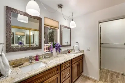 a bathroom with two sinks and two mirrors at Spacious Riverfront home in South Lake Tahoe