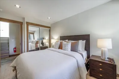 a bedroom with a large white bed and a mirror at Indian Hills 6021 townhouse in Truckee