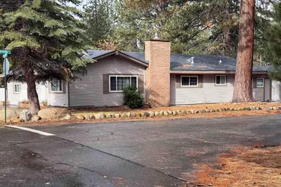 a white house with a tree and a street at South Lake Tahoe Charm in South Lake Tahoe