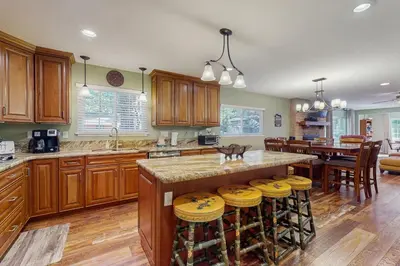 a kitchen with wooden cabinets and a bar with stools at South Lake Tahoe Charm in South Lake Tahoe
