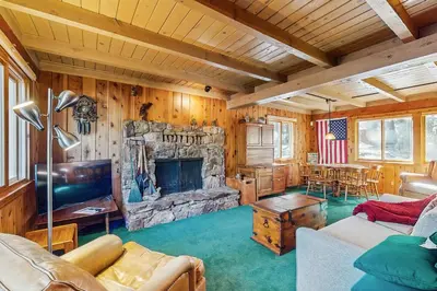 a living room with a stone fireplace in a house at Tahoe Getaway in Homewood