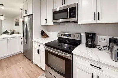 a kitchen with white cabinets and a black stove top oven at Sierra Pines Retreat Tahoe in South Lake Tahoe