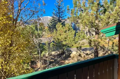 a view of a mountain from a deck with trees at Chateau Sans Nom 38 in Mammoth Lakes