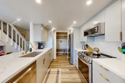 a kitchen with white cabinets and wooden floors at Sierra Megeve 31 in Mammoth Lakes