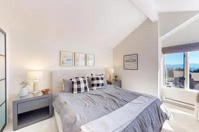 a white bedroom with a bed and a window at Sierra Megeve 31 in Mammoth Lakes