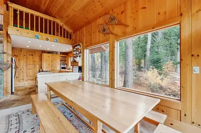 a large wooden table in a kitchen with windows at Bear Creek Pond Chalet in Alpine Meadows