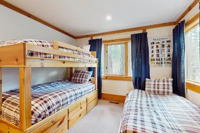 two bunk beds in a small room withwindows at Bear Creek Pond Chalet in Alpine Meadows