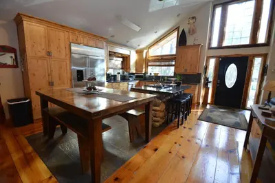 a large kitchen with wooden floors and a large wooden table at Owens Den- Lake AreaFree Night Special in Bass Lake