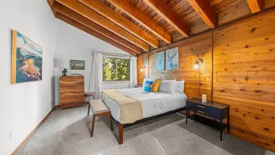 a bedroom with a bed and a wooden wall at Hot Tub Sauna Forest Views in Tahoe Donner Cedar Summit by Avantstay in Truckee