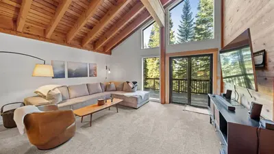 a living room with a couch and a tv at Hot Tub Sauna Forest Views in Tahoe Donner Cedar Summit by Avantstay in Truckee