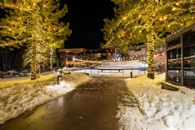 a street covered in snow with christmas lights at Remodeled Second Floor Valley View suite in Olympic Valley